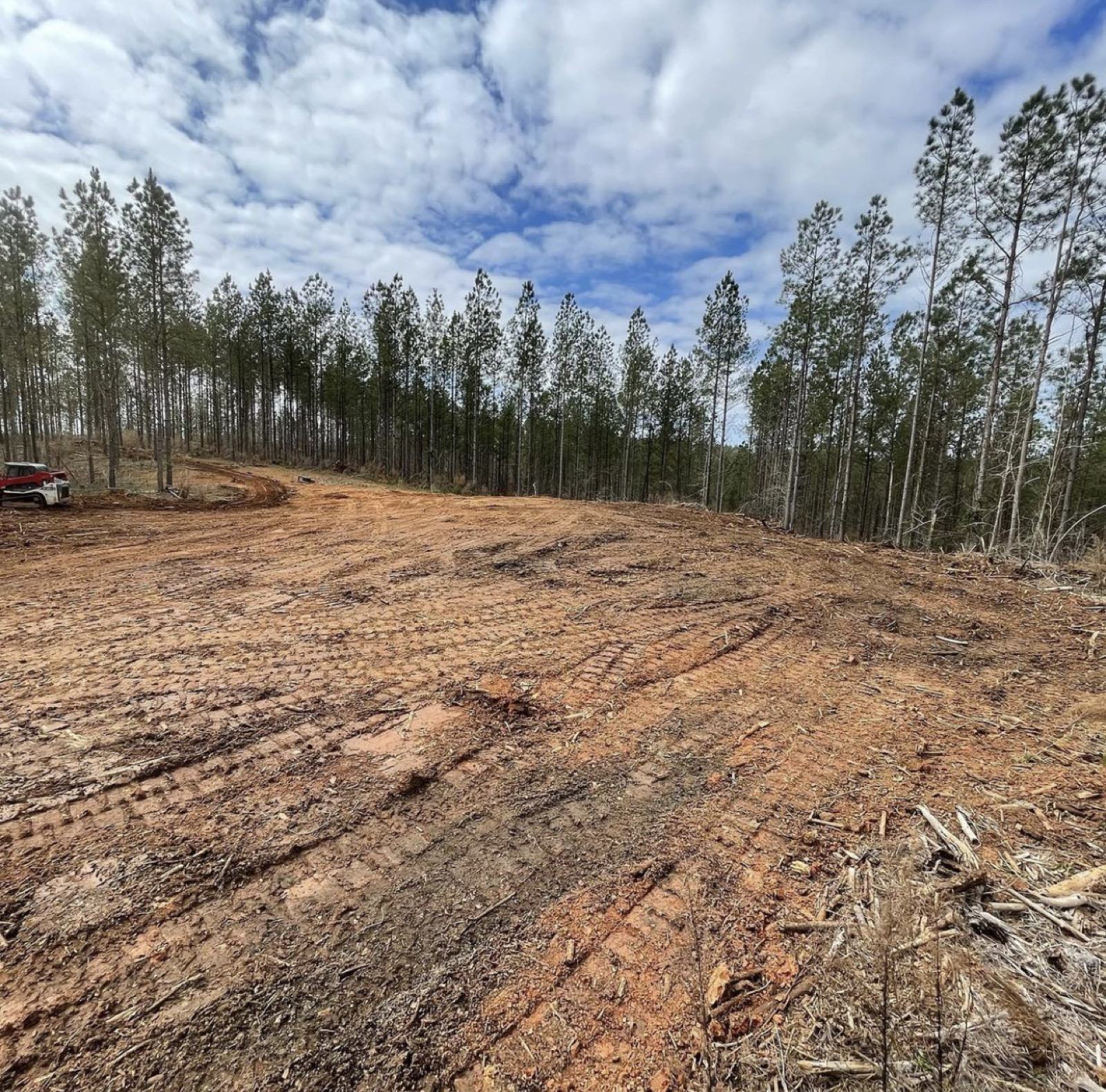 Graded West Georgia jobsite with excavator and cleared, leveled ground under an open sky