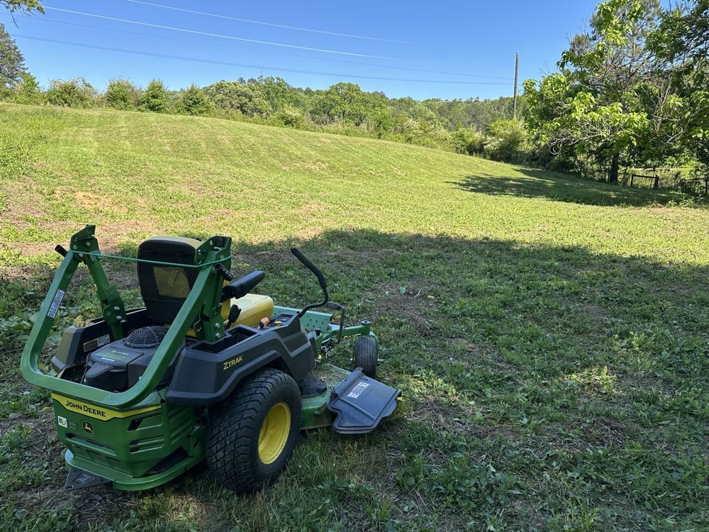 Tractor bush hogging a green pasture